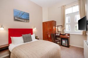 布里斯托布里斯托尔克利夫顿酒店的一间卧室配有一张床、一张书桌和一台电视