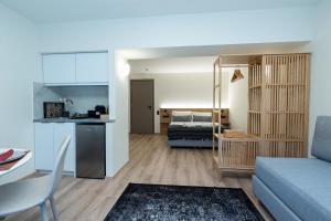 斯巴达Athens Airport Living spaces的一间带蓝色沙发的客厅和一间厨房