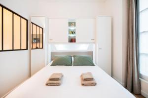 桑斯Le Laurencin Sens - Le Campagne的卧室配有白色床和毛巾