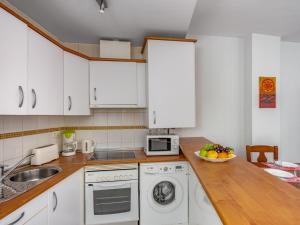 福恩吉罗拉Apartment Torrealba by Interhome的厨房配有白色橱柜,柜台上放着一碗水果