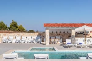 阿菲托斯Anna Mare Luxury Apartments的一个带游泳池和椅子的庭院和一间酒吧