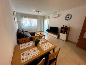 阿利坎特Alicante Hills Luxury Beach Apartment的一间带餐桌的客厅和一间带桌子的客厅