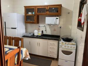 阿瓜斯迪林多亚apartamento águas de lindoia itaigara的小厨房配有炉灶和冰箱