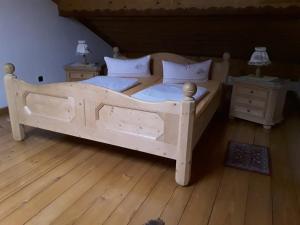 诺伊舍瑙Ferienhäuser zum Badeweiher的一间卧室配有木床和2个床头柜