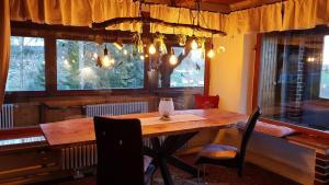 诺伊舍瑙Ferienhäuser zum Badeweiher的一间带木桌和窗户的用餐室