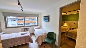 圣卡洛斯-德巴里洛切M382 Hotel Bariloche的带两张床和绿椅的客房