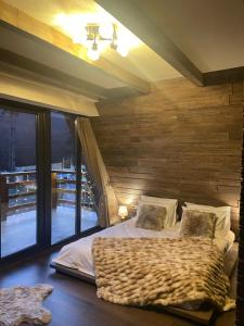 彼得罗沙尼Valea Mosului - Cozy A Frame的一间卧室配有一张木墙床