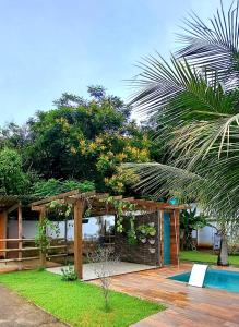 里约热内卢Casa com piscina e muita tranquilidade的一个带木制凉棚和游泳池的花园