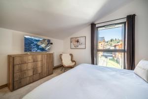 莱热Apartment Clematis Les Gets- BY EMERALD STAY的一间卧室设有一张床和一个窗口