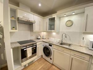 珀弗利特Spacious 2 bed flat ideal for long stays的厨房配有水槽和洗衣机