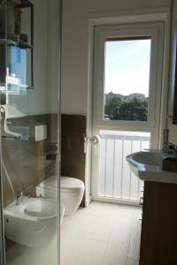 韦尔巴尼亚La perla del lago的一间带卫生间、水槽和窗户的浴室