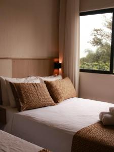 伊瓜苏伊瓜苏快捷酒店的带窗户的客房内的两张床