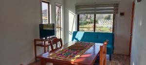 拉塞雷纳Fogones del Valle的一间带桌子和蓝色沙发的用餐室