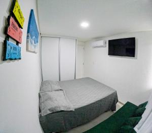 嘎林海斯港casa de veraneio - casa 9 - condomínio azul mar - Porto de Galinhas的一间带床和电视的小卧室