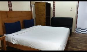 穆索里FabHotel Rudraksh Resort的卧室配有带蓝色枕头的大型白色床