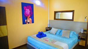 瓜纳切洛斯WANNAQUEROS SUITES的一间卧室配有一张带蓝色床单和镜子的床