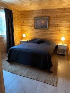 基蒂莱Villa Länsitaalo的卧室配有木墙内的一张床