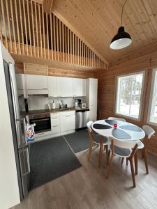 基蒂莱Villa Länsitaalo的厨房配有白色橱柜和桌椅