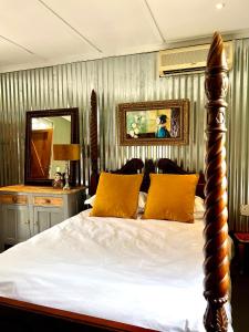 德班Terebinte Bed & Breakfast的一间卧室配有一张带黄色枕头和镜子的床