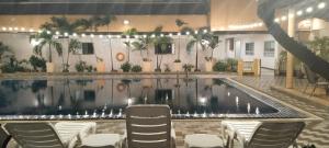 曼谷Tèja Hotel的一座带椅子的建筑中的游泳池