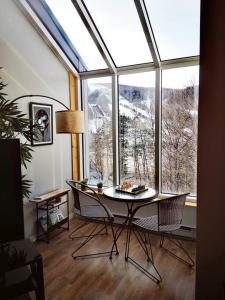 斯托纳姆Condo sur 2 niveaux avec magnifique vue sur la montagne的客房设有桌椅和大窗户。