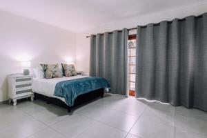 开普敦Cornerstone Guesthouse的一间卧室配有床和带窗帘的窗户