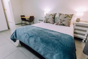 开普敦Cornerstone Guesthouse的一间卧室配有一张带蓝色毯子的床