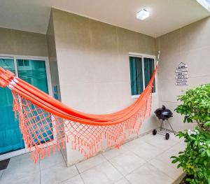 嘎林海斯港casa de veraneio - casa 9 - condomínio azul mar - Porto de Galinhas的房子边的橙色吊床