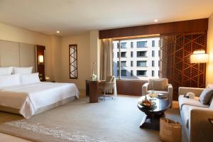 科威特Jumeirah Messilah Beach Kuwait的酒店客房设有床和客厅。