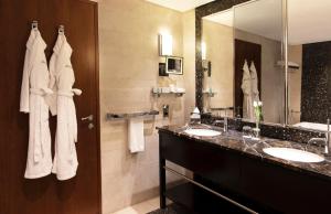 科威特Jumeirah Messilah Beach Kuwait的一间带两个盥洗盆和大镜子的浴室