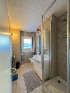 帕苏德尔托纳莱Appartamento Biancaneve的带淋浴、卫生间和盥洗盆的浴室