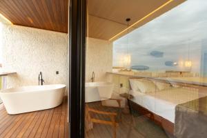 圣米格尔-杜戈斯托苏Nanii Hotel的带浴缸的浴室和大窗户