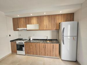 卢汉德库约HORNEROS Duplex En Lujan de Cuyo Mendoza的厨房配有白色冰箱和木制橱柜。