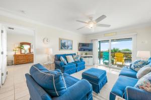 布雷登顿海滩Capri Condo A的客厅配有蓝色的沙发和吊扇