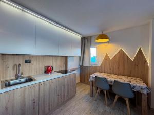 帕苏德尔托纳莱Appartamento Biancaneve的厨房配有桌椅和水槽。
