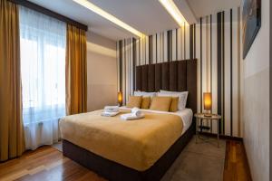 贝尔格莱德Apartments Feel Belgrade的一间卧室配有一张大床和两条毛巾