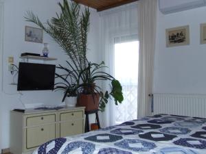 科马罗姆Czanek Apartman的一间卧室配有床和植物梳妆台