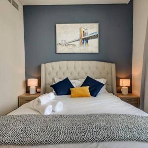 迪拜Beachwalk Luxury 2BR with Infinity Pool and Views的一间卧室配有一张带蓝色墙壁的大床