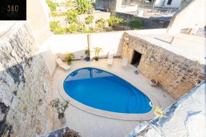 ŻebbuġA stunning, townhouse with magnificent pool area by 360 Estates的大楼游泳池的顶部景色
