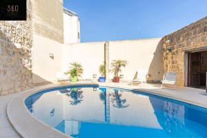 ŻebbuġA stunning, townhouse with magnificent pool area by 360 Estates的大楼前的游泳池