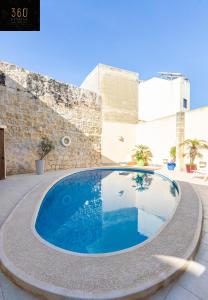 ŻebbuġA stunning, townhouse with magnificent pool area by 360 Estates的庭院中央的游泳池