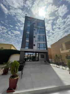 努瓦克肖特Urban Hotel Nouakchott的一座高大的建筑,有很多窗户和长凳