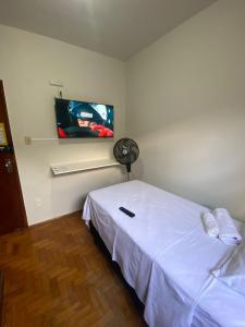 乌贝兰迪亚Pousada automática sem recepção 1的卧室配有白色的床和平面电视。