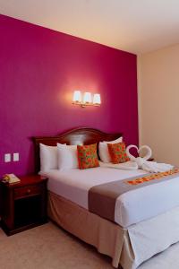 坎佩切坎佩切广场酒店的一间卧室配有两张紫色墙壁的床