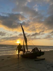 伊卡普伊POUSADA CHALÉ PARAÍSO - Icapui的一名男子在海滩上乘坐帆船行走
