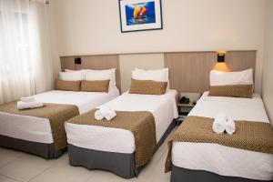 伊瓜苏伊瓜苏快捷酒店的酒店客房,配有三张床和毛巾