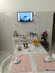 巴尼奥雷焦A CASA IDA的厨房配有桌子,墙上配有电视