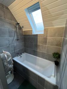 希尔蒂盖姆Chez Régine, 45m2 privés的带浴缸的浴室和窗户。