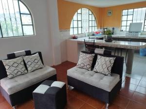 安巴托4 Cuarto independiente con sala en Ambato的一间带两把椅子的客厅和一间厨房