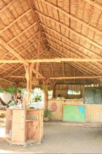 NagaroteCamping Ojo de Agua的站在木屋顶下的柜台上的女人